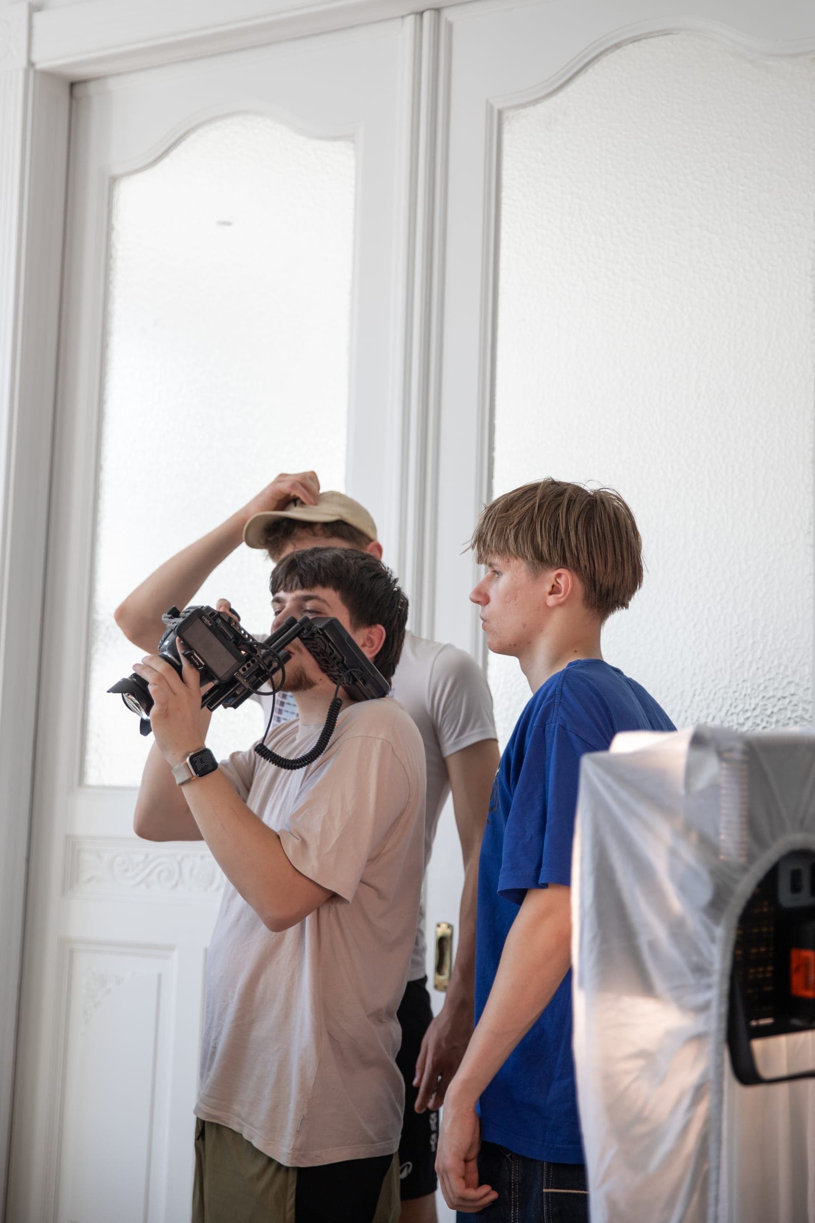 Mehrere Crewmitglieder kontrollieren gemeinsam das Bild einer Filmkamera
