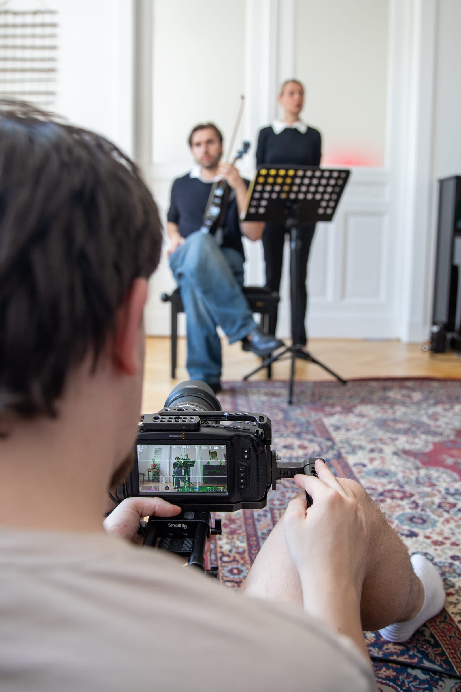 Kamera filmt zwei Mitwirkende bei einer inszenierten Musikaufnahme